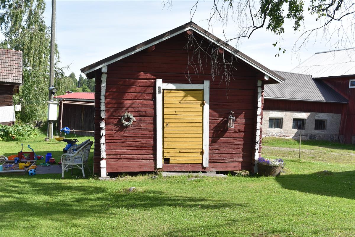 Ruoka/vilja-aitta, taustalla näkyy kivi-, betonitiili- ja lautarakentinen karjarakennus.&nbsp;(Teija Ahola&nbsp;2023)
