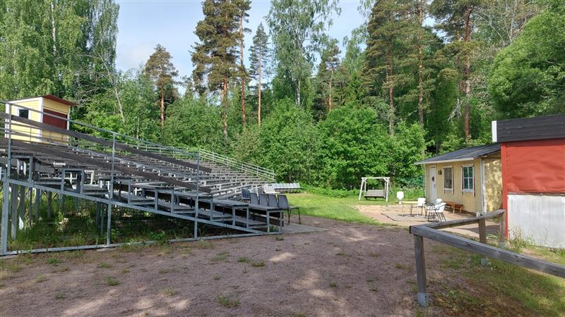 Rakennuksen päädyssä vanhan urheilukentän reunalla sijaitseva kesäteatteri.&nbsp;(Dan Ronimus&nbsp;06/2022)