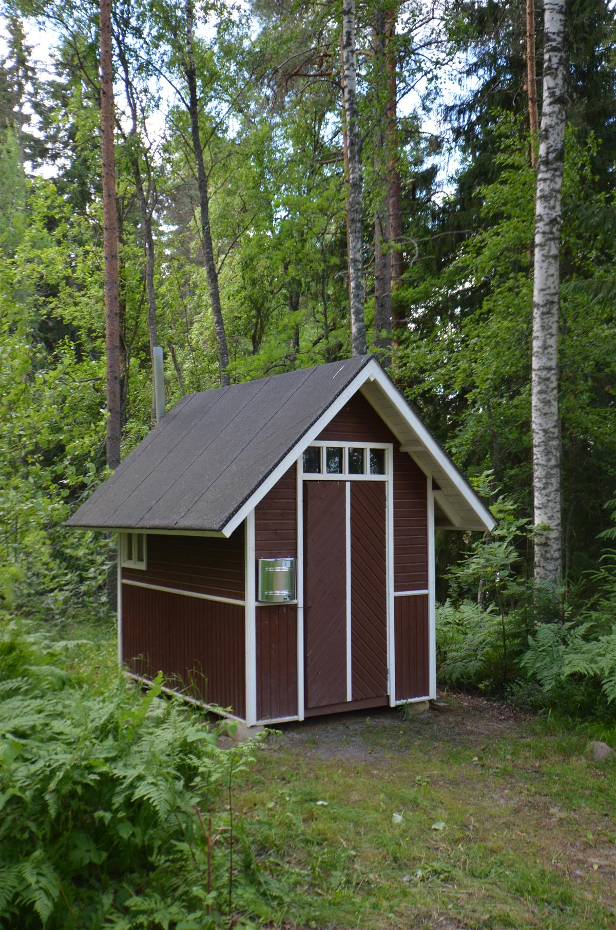 Uuden rantasaunan takana sijaitseva ulkokäymälä pohjoisesta päin kuvattuna. [Kohteen rakennukseen liitetty kuva]&nbsp;(Päivi Makkonen&nbsp;2026)