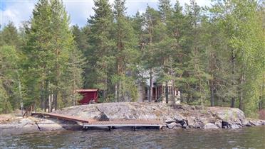 Kuva: Rakennuksen sisäänkäynnin puoleista julkisivua, jolla sijaitsee valoisa kuisti.&nbsp;(Dan Ronimus&nbsp;5/2022)