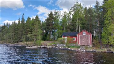 Kuva: L-kirjaimen muotoinen venevaja on aivan kiinni rannassa ja huvila sen takana puiden ympäröimänä.&nbsp;(Dan Ronimus&nbsp;5/2022)