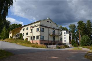 Kuva: Rantalan sairaalarakennus rannasta, kaakosta päin kuvattuna. Taustalla uudempi asuinkerrostalo.&nbsp;(Päivi Makkonen&nbsp;2026)
